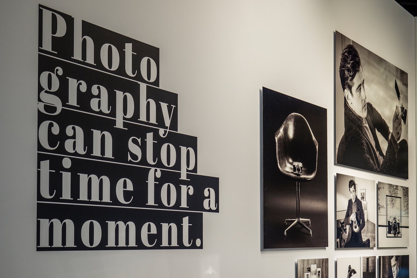 Gallery wall displaying graphic text and framed black and white photographs.